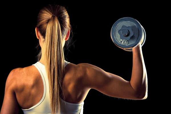 Girl athlete with dumbbells 2 kilograms