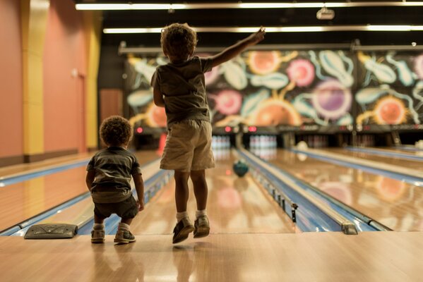 Little boys play bowling