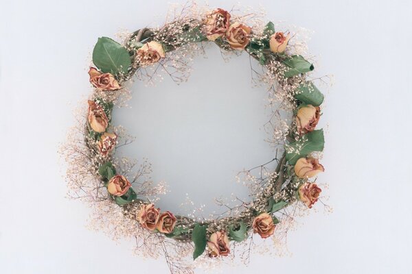 Couronne de roses et de feuilles sur fond gris