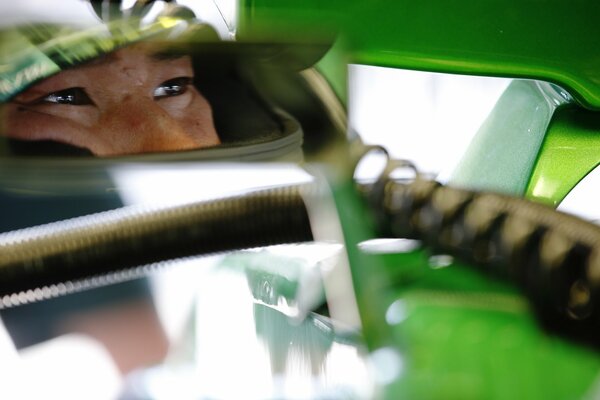 A racer with a green helmet on his head