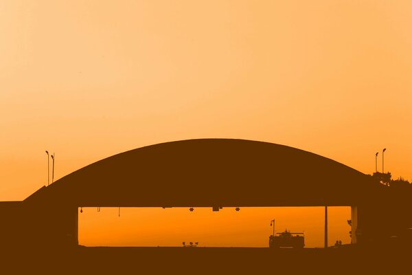 A racing car rides under a hangar