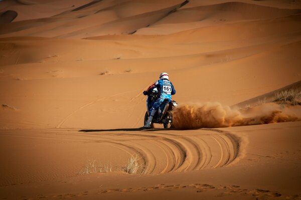 Motorradfahrer im orangefarbenen Sand