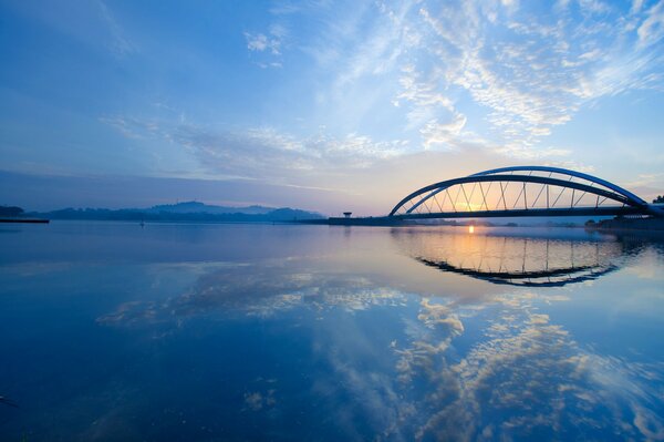 Bridge over a wide river at sunset