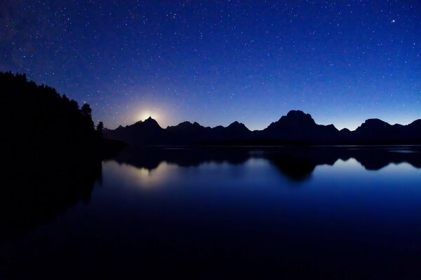 Nocne niebo nad jeziorem jest piękne