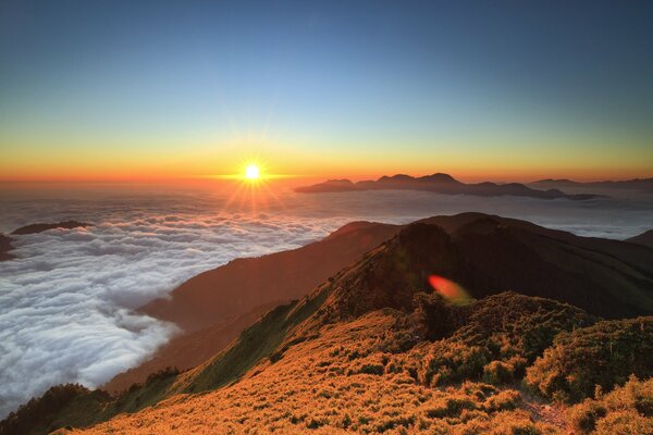 Hermoso amanecer sobre las nubes en las montañas