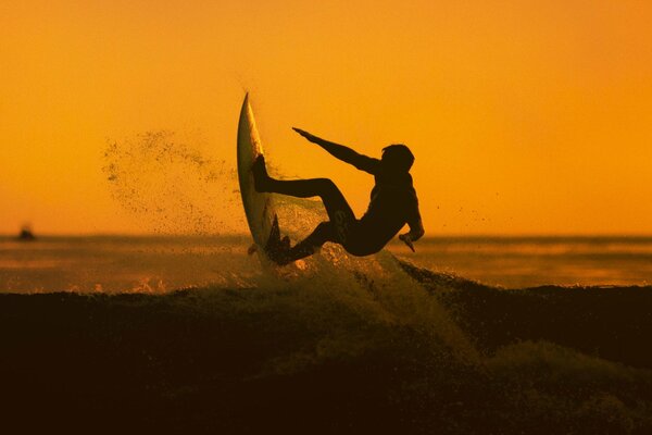 A man and a wave at sunset