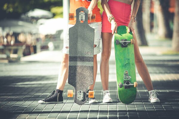 A guy and a girl are standing with skateboards