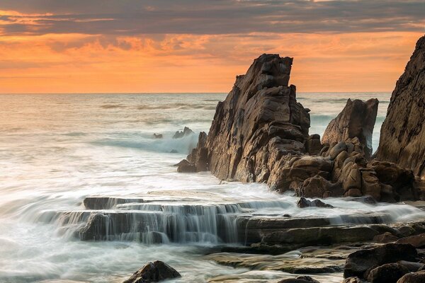 Scharfe Klippen im Meer bei Sonnenuntergang