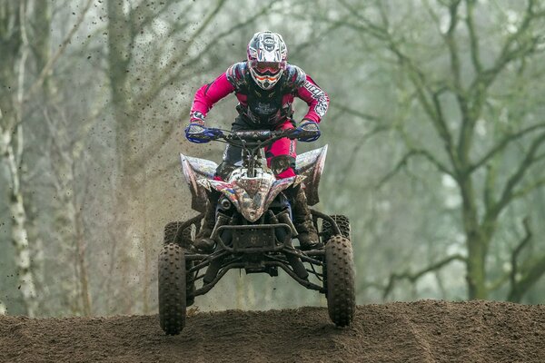 Race on quad bikes. A man in a helmet on a quad bike