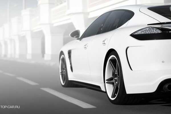 A white Porsche rushes along the autobahn