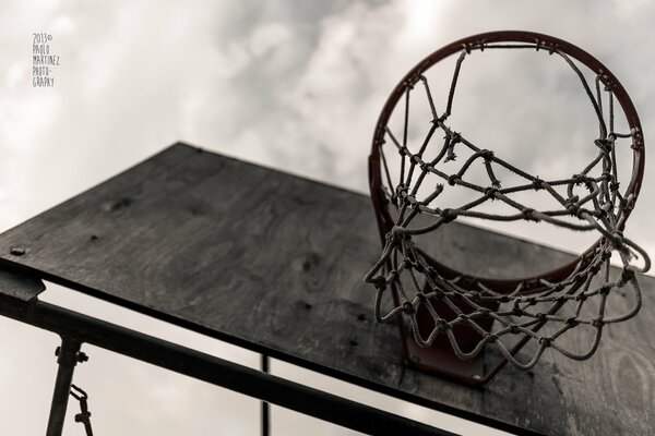 Aro de baloncesto en el escudo bajo el nebommotociclista