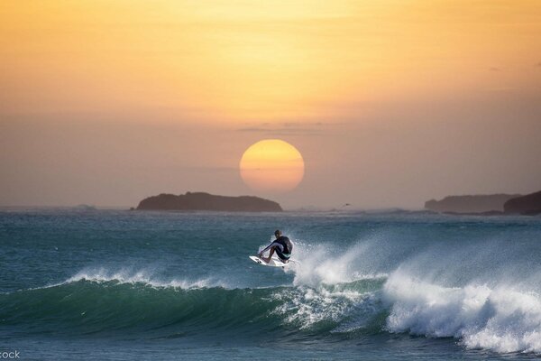 Spektakuläres Surfen im Hintergrund des Sonnenuntergangs