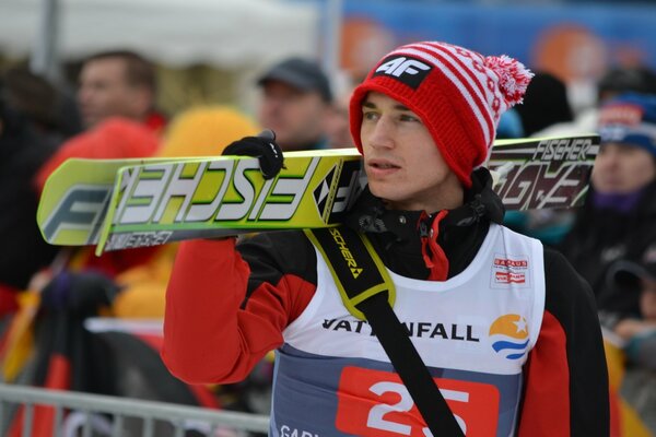 An athlete with skis leaves the track