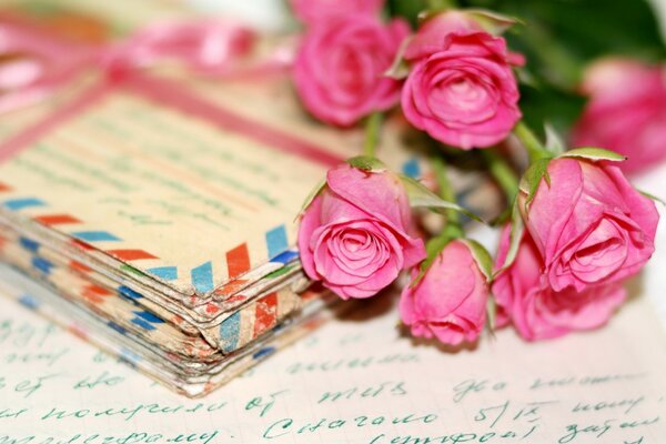 A bouquet of pink roses and a letter