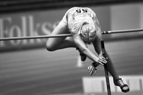 Ragazza atleta che salta sopra la barra