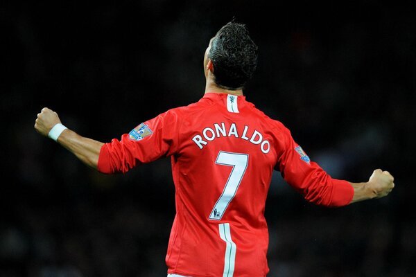 A football player in a red jersey with the number seven rejoices at the victory