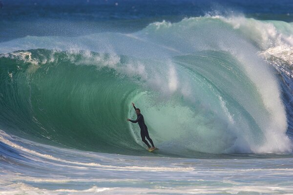 Surfer überwindet die Welle eines Tunnels am Meer