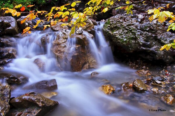 A small rocky waterfall in autumn