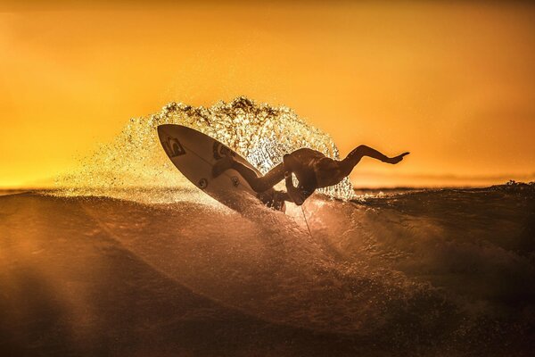 Surf al atardecer atleta atrapa la ola