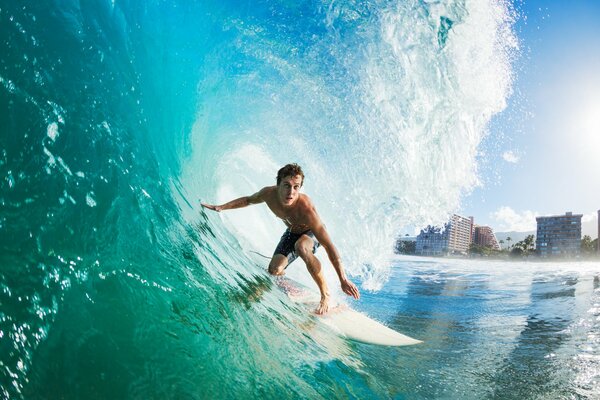 A surfer who caught a wave on the background of the town