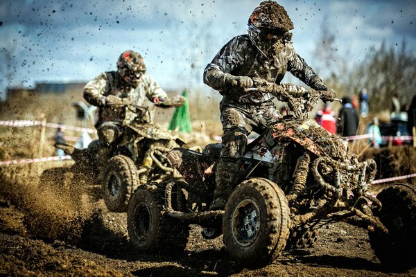 The race of athletes on quad bikes in the mud