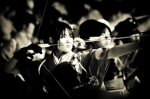Japanese girl takes aim with a bow
