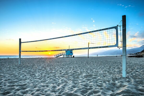 Beach volleyball at summer sunset