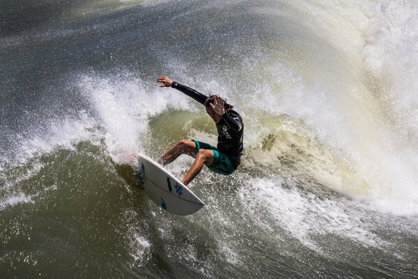 A man on a board in the crest of a sea wave