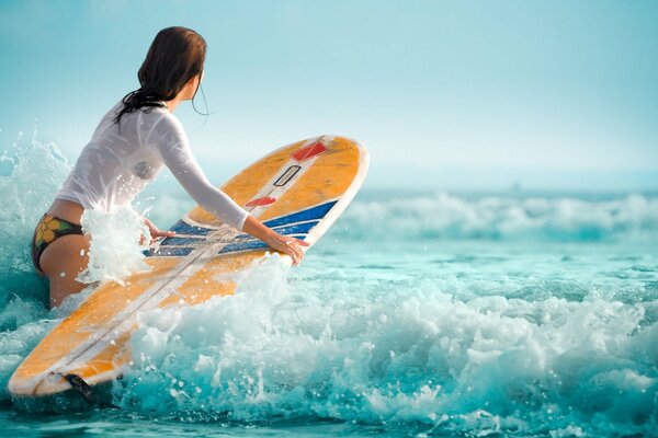 Fille sur les vagues sur une planche de surf