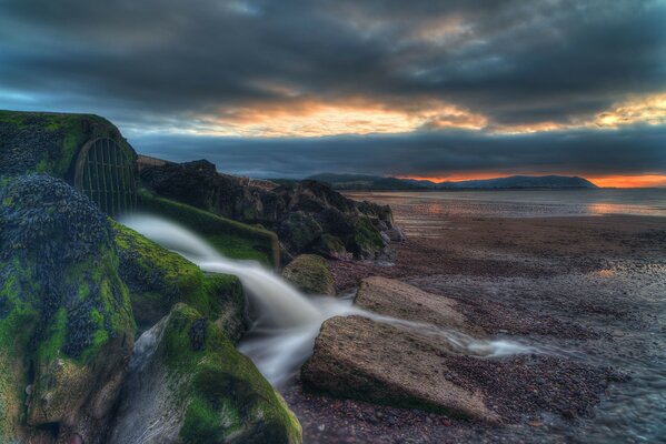 Paysage côte de mer coucher de soleil et pierres vertes