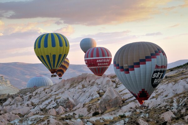 Balloons fly over the mountain landscape