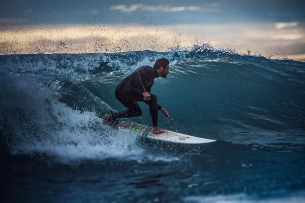 Un hombre surfea. Océano azul