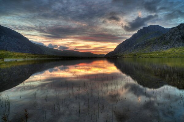 Puesta de sol de gran Bretaña con lago y montañas. bebe