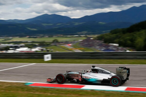 Das Rennen, die Formel 1 rennt auf der Strecke, ein schicker Blick öffnet sich auf die Berge