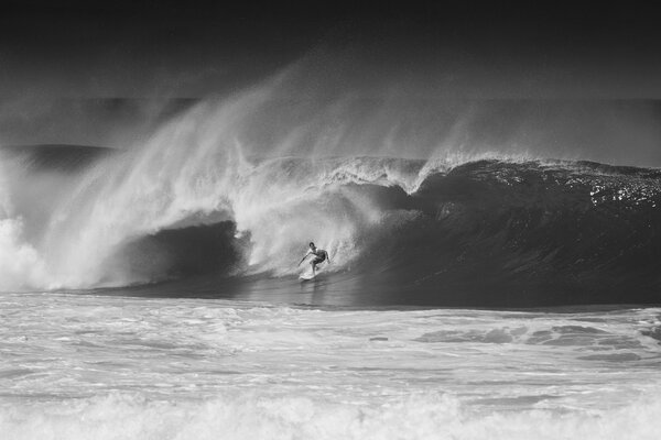 Ein Surfer auf Hawaii im Ozean hat eine große Welle gefangen. Schwarz-Weiß-Foto