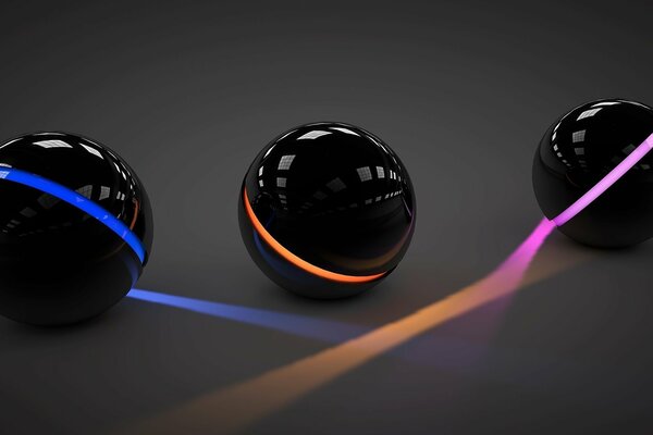 Three black balls surrounded by light of different colors