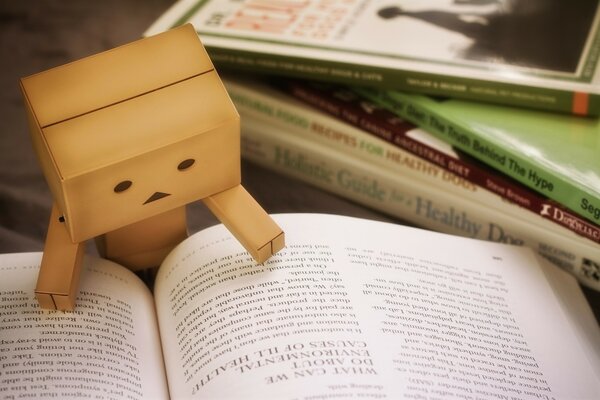 A cardboard man studying a book