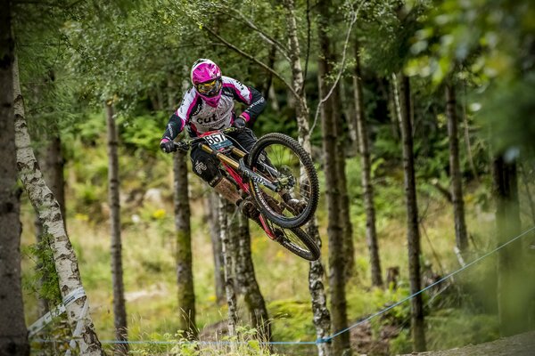 Salta il ciclista nelle corse fuoristrada nella foresta