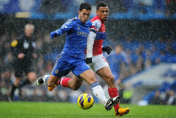 Two football players are fighting for the ball