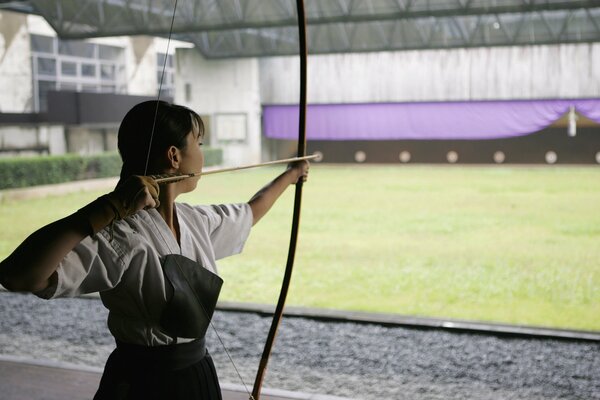 Fille avec un arc tire sur la cible