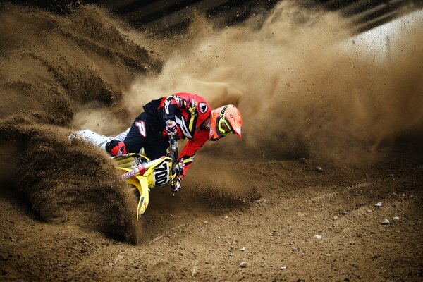 The motorcycle makes a turn in the sand during the race