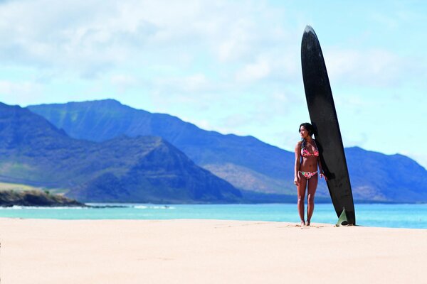 Fille en maillot de bain surfeuse sur la plage