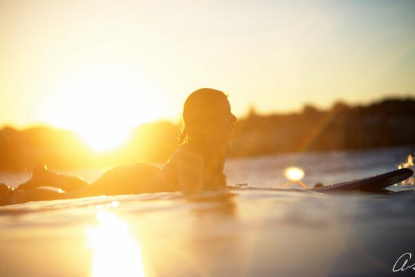 Surfer vor dem Hintergrund der untergehenden Sonne