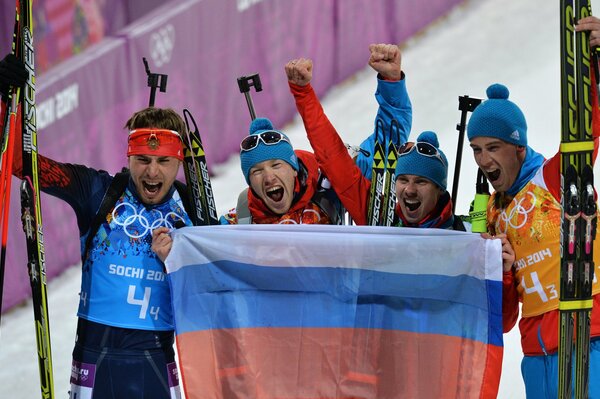 Teilnehmer der Biathlon-Staffel Anton Shipulin, Alexei Volkov, Dmitry Malyshko und Jewgeni Ustjugow, die die russische Flagge bei den Olympischen Spielen von Sotschi 2014 halten