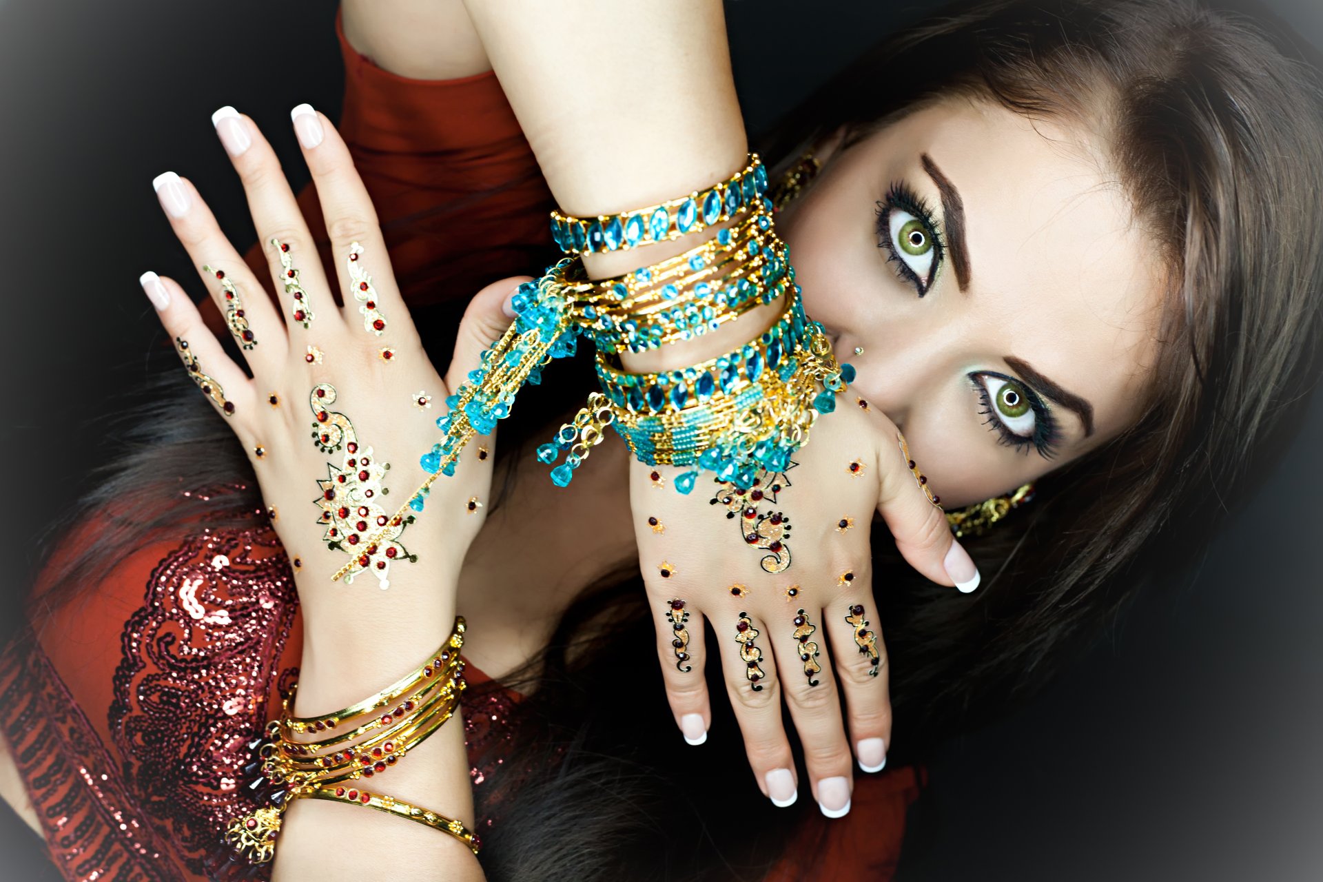 fille. regard yeux verts maquillage cheveux mains bijoux bracelets pierres indien