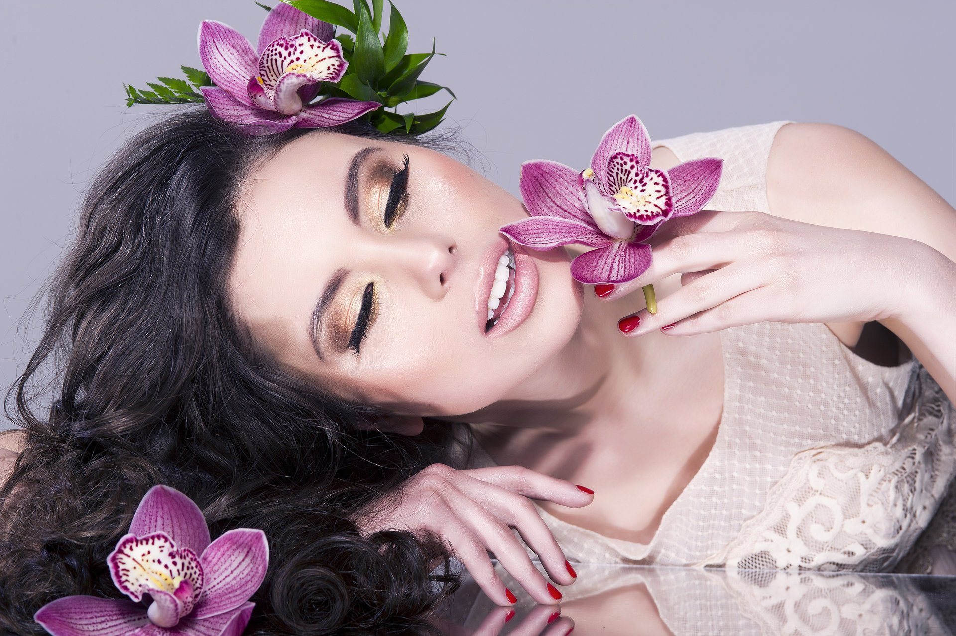 chica modelo hermoso maquillaje labios pestañas cara. cabello rizos mano flores reflexión manicura