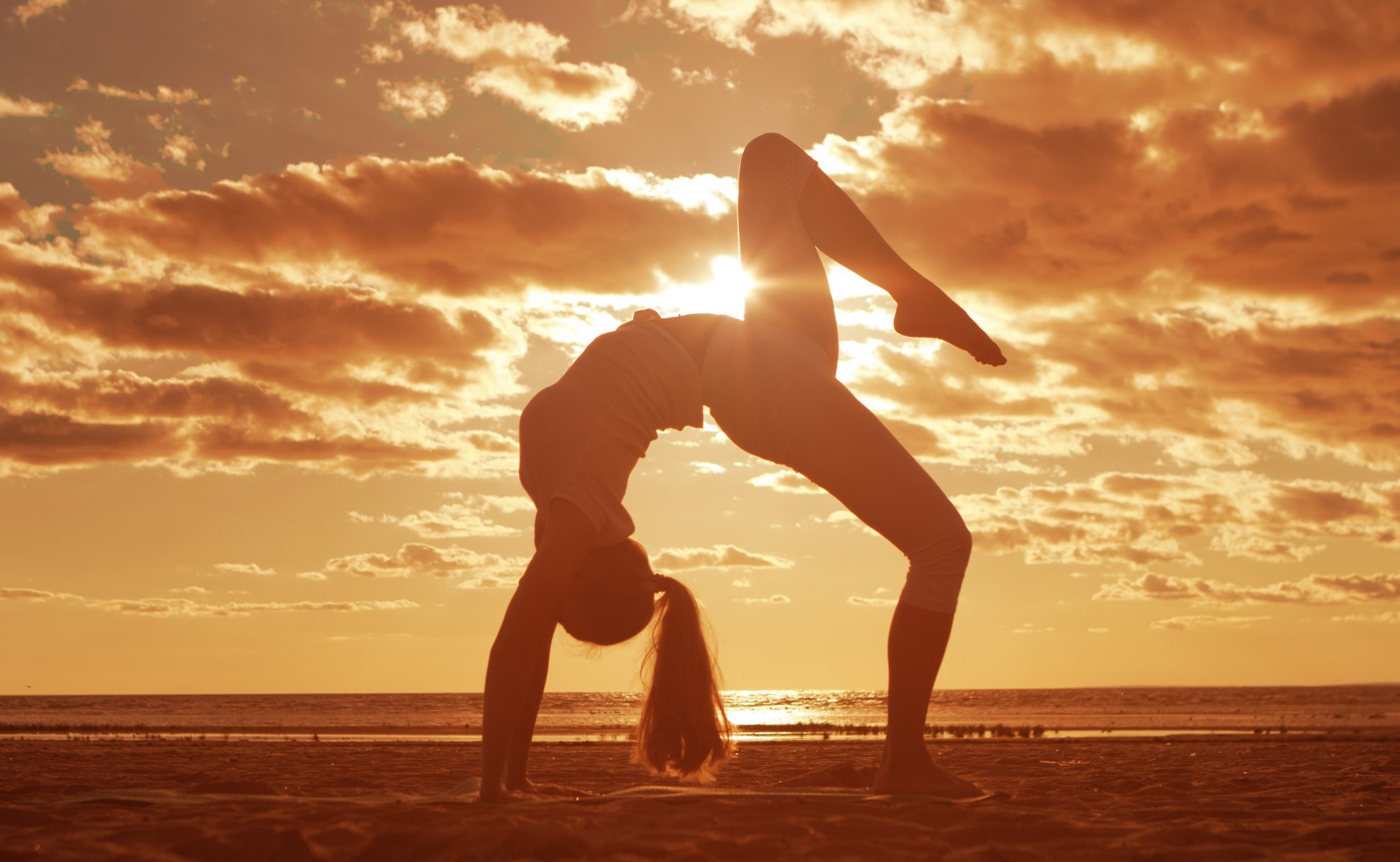 girl long-haired . sea sand beach clouds sun mat gymnastic