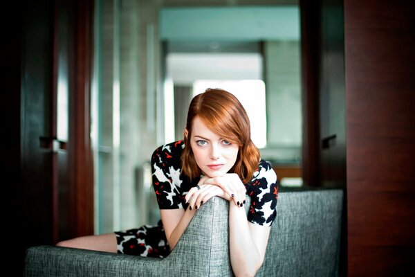 Emma Stone poses in the studio on the couch