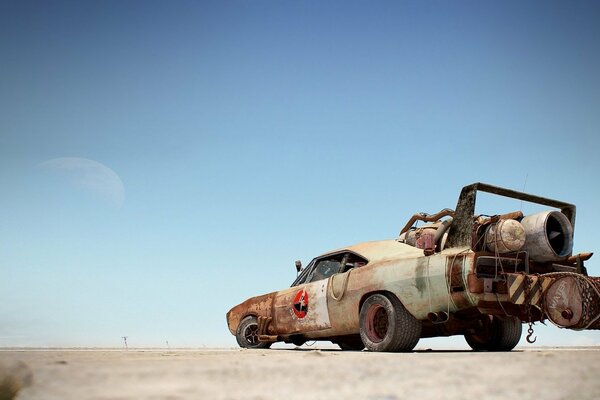 A desert with a car and a blue sky