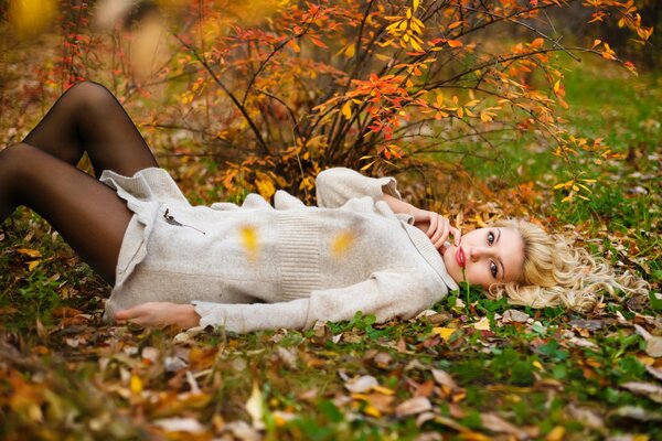 Девушка лежит на осенней листве